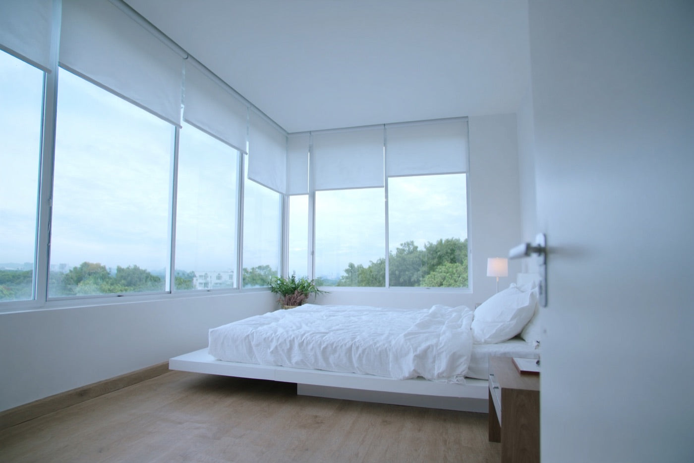 Bedroom at dawn, blinds rising to cool morning light